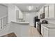 Kitchen with white cabinets, breakfast bar, stainless steel appliances, and hardwood floors at 147 Townview Dr, Woodstock, GA 30189