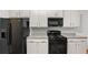 This kitchen features sleek black appliances and bright cabinetry at 147 Townview Dr, Woodstock, GA 30189