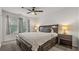 Main bedroom with ceiling fan, large windows, and bedside tables with lamps at 147 Townview Dr, Woodstock, GA 30189