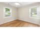 Sunny bedroom featuring hardwood floors, white trim, and two windows at 1927 Alexander Se St, Smyrna, GA 30080