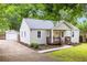 Side view of a quaint home, featuring a detached garage and a well-maintained yard with tasteful landscaping at 1927 Alexander Se St, Smyrna, GA 30080