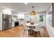Modern kitchen and dining area featuring stainless steel appliances, white cabinetry, and stylish light fixtures at 1927 Alexander Se St, Smyrna, GA 30080