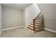 Carpeted stairway with wood and black iron railing leads to an unfinished basement at 3250 Seven Oaks Dr, Cumming, GA 30041