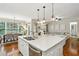 Bright, open kitchen with an island, stainless steel appliances and hardwood floors, plus a view to dining room and living space at 3250 Seven Oaks Dr, Cumming, GA 30041