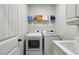 A well-equipped laundry room with washer, dryer, storage shelf, and sink at 3250 Seven Oaks Dr, Cumming, GA 30041