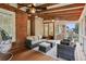 Relax on this screened porch with seating, ceiling fans, exposed wood beam ceiling, and brick siding at 3250 Seven Oaks Dr, Cumming, GA 30041