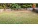 Spacious backyard enclosed by a wooden fence and backing up to thick trees at 4160 Post Oak Grv, Atlanta, GA 30349