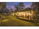 A spacious backyard features a hot tub, patio seating, lush green grass, and evening lighting at 7265 Hunters Branch Dr, Sandy Springs, GA 30328