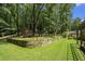 A lush backyard featuring a stone retaining wall with flowers and a neatly kept lawn at 7265 Hunters Branch Dr, Sandy Springs, GA 30328