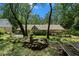 Enjoy the greenery of the backyard featuring a buddha statue, forest, back of house, patio, and lush lawn at 7265 Hunters Branch Dr, Sandy Springs, GA 30328