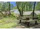Serene backyard with a stone picnic table, garden, and mature trees offering shade at 7265 Hunters Branch Dr, Sandy Springs, GA 30328