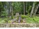 A stone retaining wall with a waterfall feature and a small shed in the backyard forest at 7265 Hunters Branch Dr, Sandy Springs, GA 30328