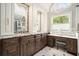 A luxurious bathroom featuring double sinks, white cabinets, granite counters, and a vanity counter at 7265 Hunters Branch Dr, Sandy Springs, GA 30328
