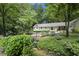 Inviting home exterior featuring stone facade, mature landscaping, and charming wooden bridge at 7265 Hunters Branch Dr, Sandy Springs, GA 30328