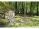 Small wood shed in a wooded area of the backyard, with gravel path and landscape lighting at 7265 Hunters Branch Dr, Sandy Springs, GA 30328