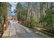 Scenic wooden bridge over a gently flowing stream surrounded by a serene wooded area at 7265 Hunters Branch Dr, Sandy Springs, GA 30328