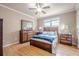 Cozy bedroom with wood flooring, a ceiling fan, and a full bedroom set, including a bed, nightstands, and dresser at 1765 Dew Pl, Marietta, GA 30064