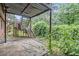 Backyard featuring a concrete patio and metal stairs, with overgrown bushes at 3232 Abbeywood Dr, Decatur, GA 30034