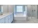 Elegant bathroom with a soaking tub, glass-enclosed shower, and double vanity at 113 Canal St, Hampton, GA 30228