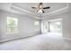 Spacious bedroom featuring tray ceilings, plush carpet, and large windows for natural light at 113 Canal St, Hampton, GA 30228