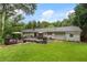 Exterior view of home's backyard with deck, patio seating, large yard, and mature trees at 2109 Allgood Rd, Marietta, GA 30062