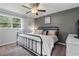 Cozy bedroom featuring a dark grey accent wall, ceiling fan, and a window with natural light at 2109 Allgood Rd, Marietta, GA 30062