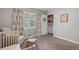 Bright bedroom features a crib, a window with decorative curtains, and ample space at 2109 Allgood Rd, Marietta, GA 30062