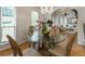 Bright dining room with glass table, chandelier, hardwood floors, and a view to the living room at 2833 Golden Club Bnd, Austell, GA 30106