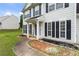 Close up of the entrance with landscaping, dark shutters, and a covered porch at 2833 Golden Club Bnd, Austell, GA 30106