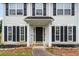 Detailed entrance view with landscaping, dark shutters, covered porch and black front door at 2833 Golden Club Bnd, Austell, GA 30106