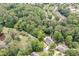 Aerial view showing the house nestled among mature trees, next to a pond and a long driveway at 4920 Hampton Lake Dr, Marietta, GA 30068