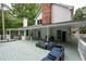 The large, covered gray deck has outdoor furniture, a bike, and is surrounded by mature trees at 4920 Hampton Lake Dr, Marietta, GA 30068