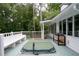 The deck is large, painted gray, has a hot tub and a bench and is surrounded by mature trees at 4920 Hampton Lake Dr, Marietta, GA 30068