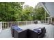 The deck is large, painted gray, has outdoor furniture, a grill, and is surrounded by mature trees at 4920 Hampton Lake Dr, Marietta, GA 30068