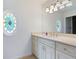Bright bathroom features custom vanity with white cabinets and an oval stained glass window at 4920 Hampton Lake Dr, Marietta, GA 30068