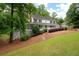 Inviting two-story home with a wraparound porch and lush landscaping, nestled among mature trees at 4920 Hampton Lake Dr, Marietta, GA 30068