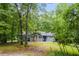 Charming home featuring stone chimney, complemented by the lush, mature trees surrounding the property at 4985 Watkins Ct, Winston, GA 30187