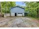 Exterior angle of house featuring garage door, unfinished driveway and blue siding at 4985 Watkins Ct, Winston, GA 30187