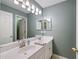 Bathroom featuring double sink vanity, large mirror, and neutral wall color at 206 Kingsley Way, Woodstock, GA 30188