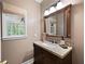 Stylish powder room features a granite countertop, dark wood vanity, and framed mirror at 206 Kingsley Way, Woodstock, GA 30188