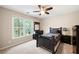 Comfortable bedroom with large window overlooking the yard, ceiling fan and dark furnishings at 206 Kingsley Way, Woodstock, GA 30188
