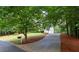Long driveway leading to a well-maintained house with a lush green lawn and mature trees offering privacy at 206 Kingsley Way, Woodstock, GA 30188