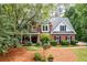 Charming two-story brick home with a welcoming front porch and lush landscaping, creating a picturesque curb appeal at 206 Kingsley Way, Woodstock, GA 30188