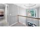 Upstairs hallway features neutral paint, a large window, and a view of the bedroom at 206 Kingsley Way, Woodstock, GA 30188