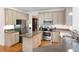 Well-lit kitchen features stainless steel appliances, center island, granite countertops, and hardwood floors at 206 Kingsley Way, Woodstock, GA 30188