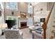 Open-concept living room with a fireplace, large windows, a staircase, and views of the dining and kitchen area at 206 Kingsley Way, Woodstock, GA 30188