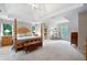 Large main bedroom with a tray ceiling, four-poster bed, and sitting area at 206 Kingsley Way, Woodstock, GA 30188