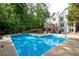 Relaxing backyard oasis featuring a large in-ground pool, deck, and surrounded by mature trees at 206 Kingsley Way, Woodstock, GA 30188
