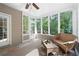 Bright sunroom with floor-to-ceiling windows provides a serene atmosphere to unwind and appreciate nature at 206 Kingsley Way, Woodstock, GA 30188