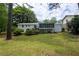Grassy backyard of home featuring a screened-in porch, a deck, and mature trees at 2519 Lauderdale Ne Dr, Atlanta, GA 30345
